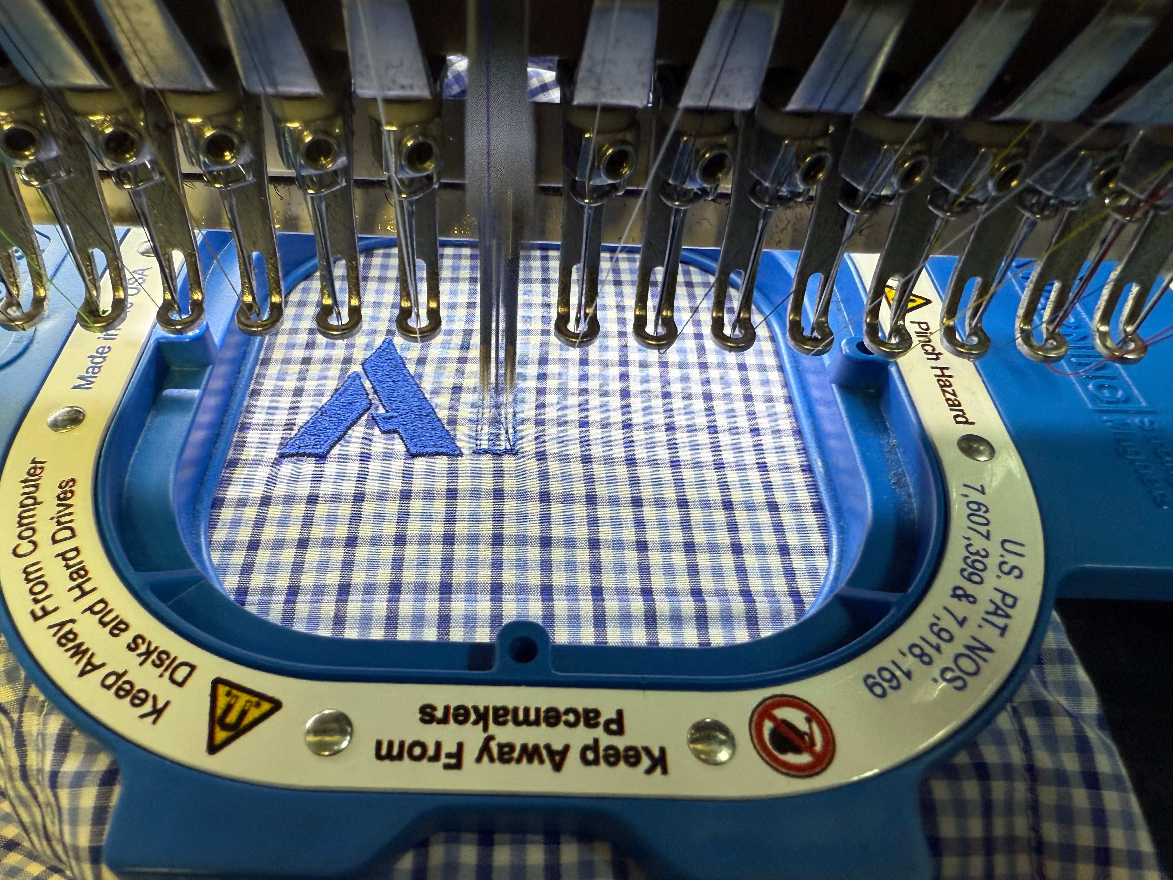 Custom embroidery machine stitching company logo on corporate shirt in Australia